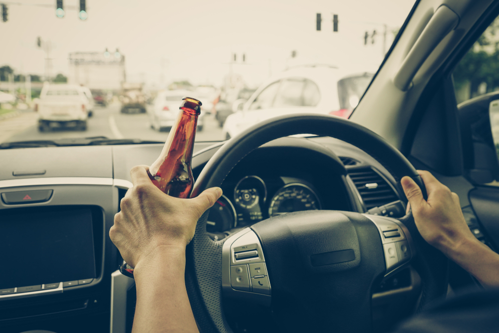 a driver holding alcoholic bottle while driving