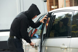 Thief stealing automobile car at daylight street in city