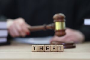 Text Theft and female judge knocking gavel at courtyard. Arbiter performs verdict in case of robbery